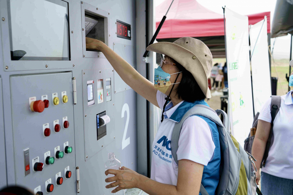 志工們將拾起的寶特瓶投入「好歸塑專車」，讓廢棄塑料空瓶可以直接粉碎、縮小體積，未來將可再製成購物袋、寶特衣、悠遊卡等生活用品